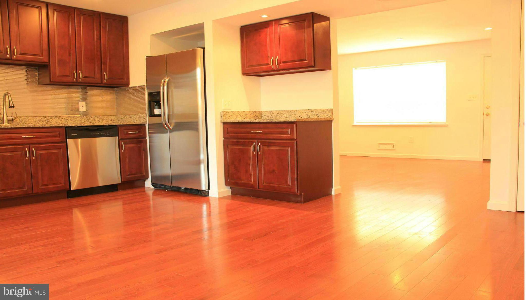 4772 Melbourne Road Baltimore, MD 21229 - Photo 12 of 30 a bathroom with a granite countertop sink and a refrigerator