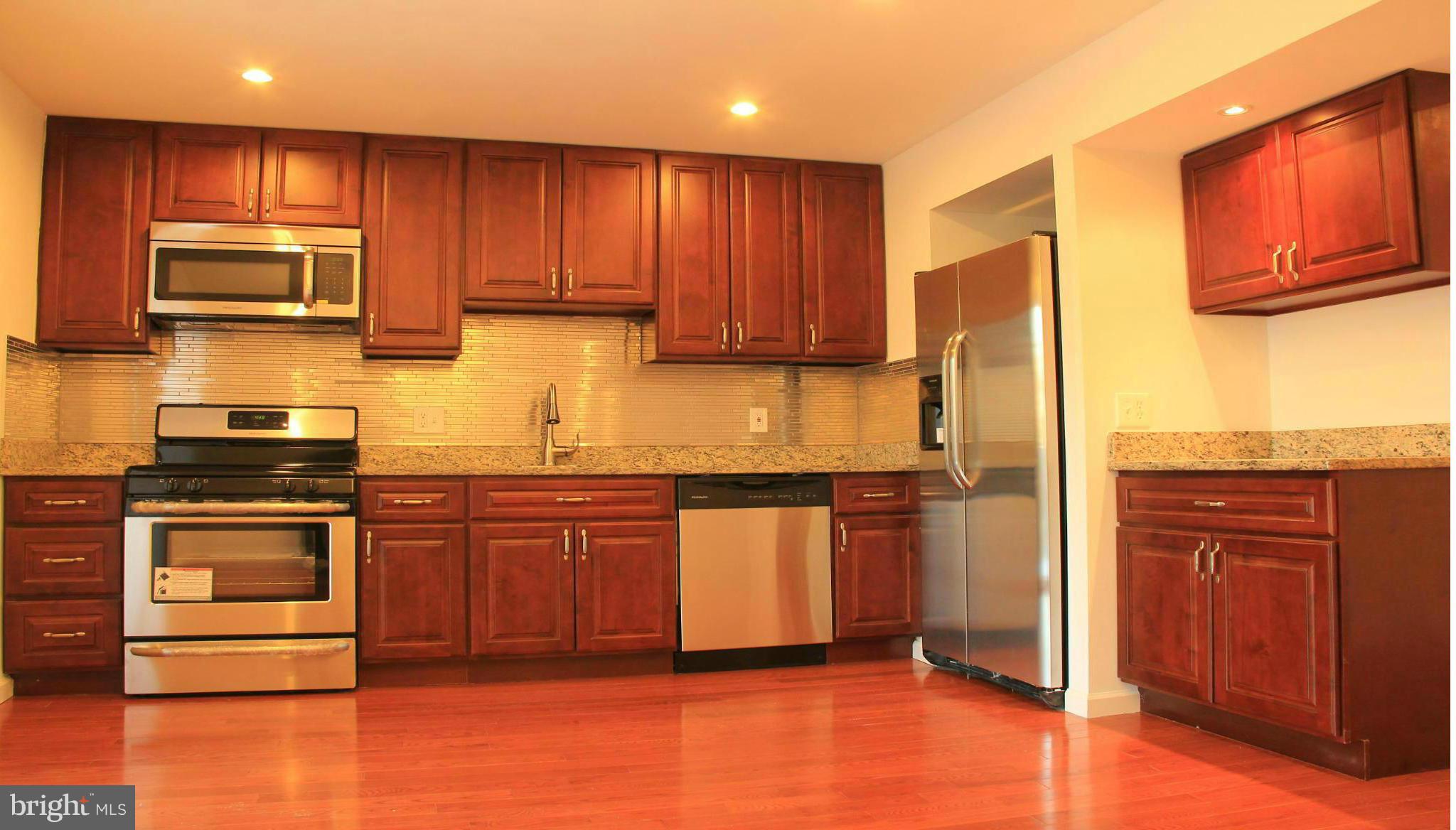 4772 Melbourne Road Baltimore, MD 21229 - Photo 15 of 30 a kitchen with stainless steel appliances granite countertop a refrigerator stove top oven and sink