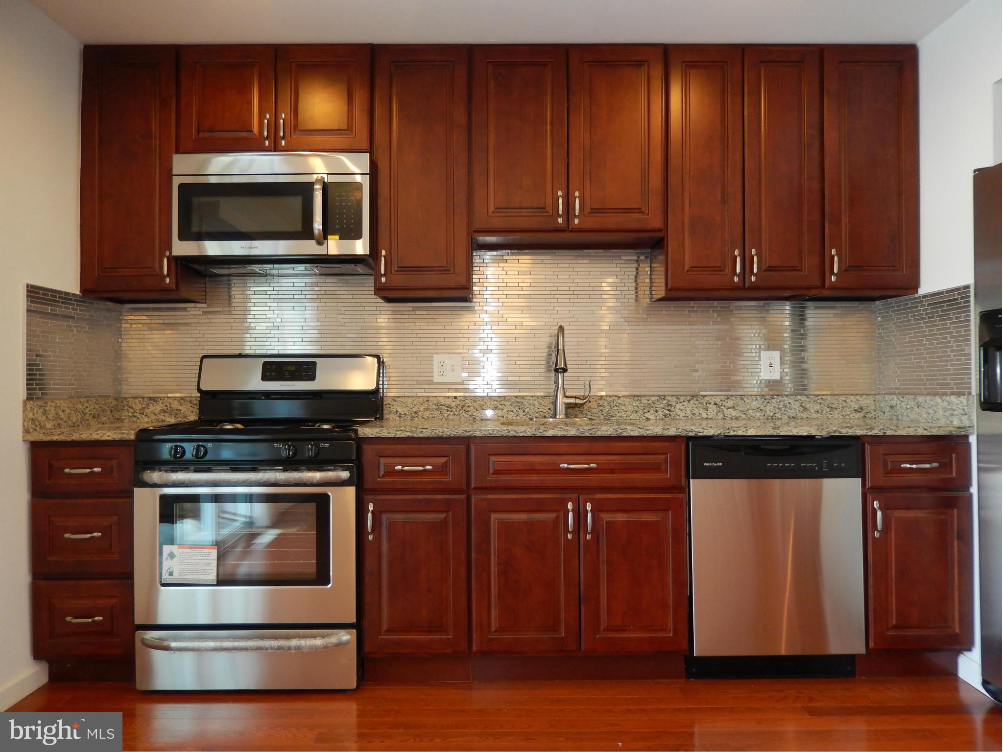 4772 Melbourne Road Baltimore, MD 21229 - Photo 16 of 30 a kitchen with stainless steel appliances granite countertop wooden cabinets and a stove top oven