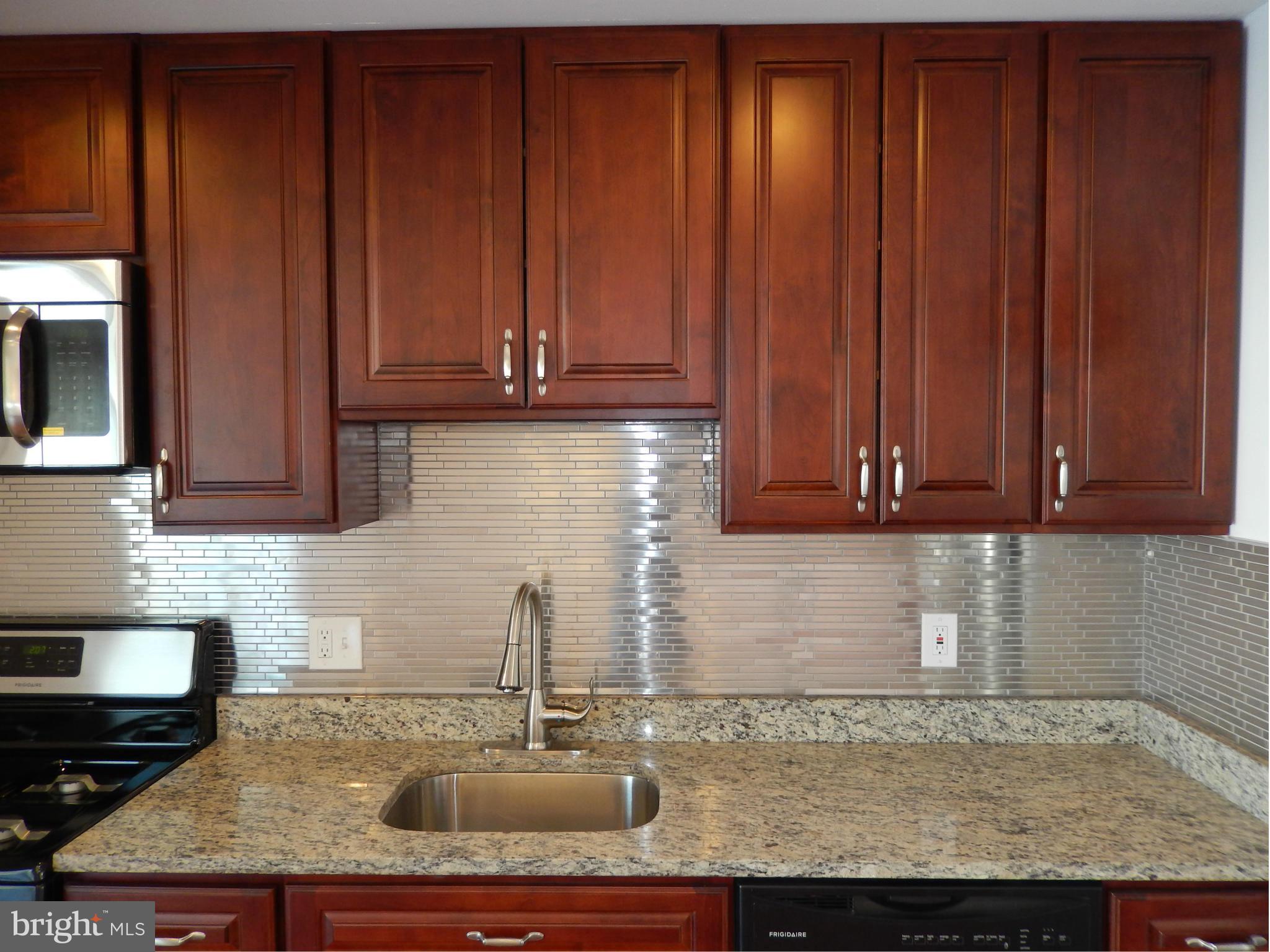 4772 Melbourne Road Baltimore, MD 21229 - Photo 17 of 30 a kitchen with granite countertop wooden cabinets and a sink