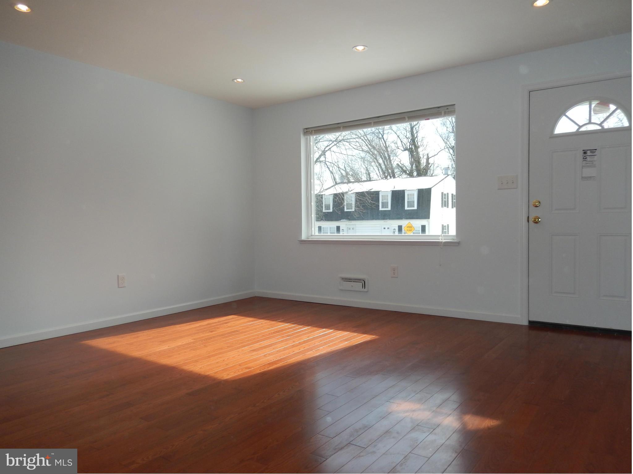 4772 Melbourne Road Baltimore, MD 21229 - Photo 3 of 30 an empty room with wooden floor and windows