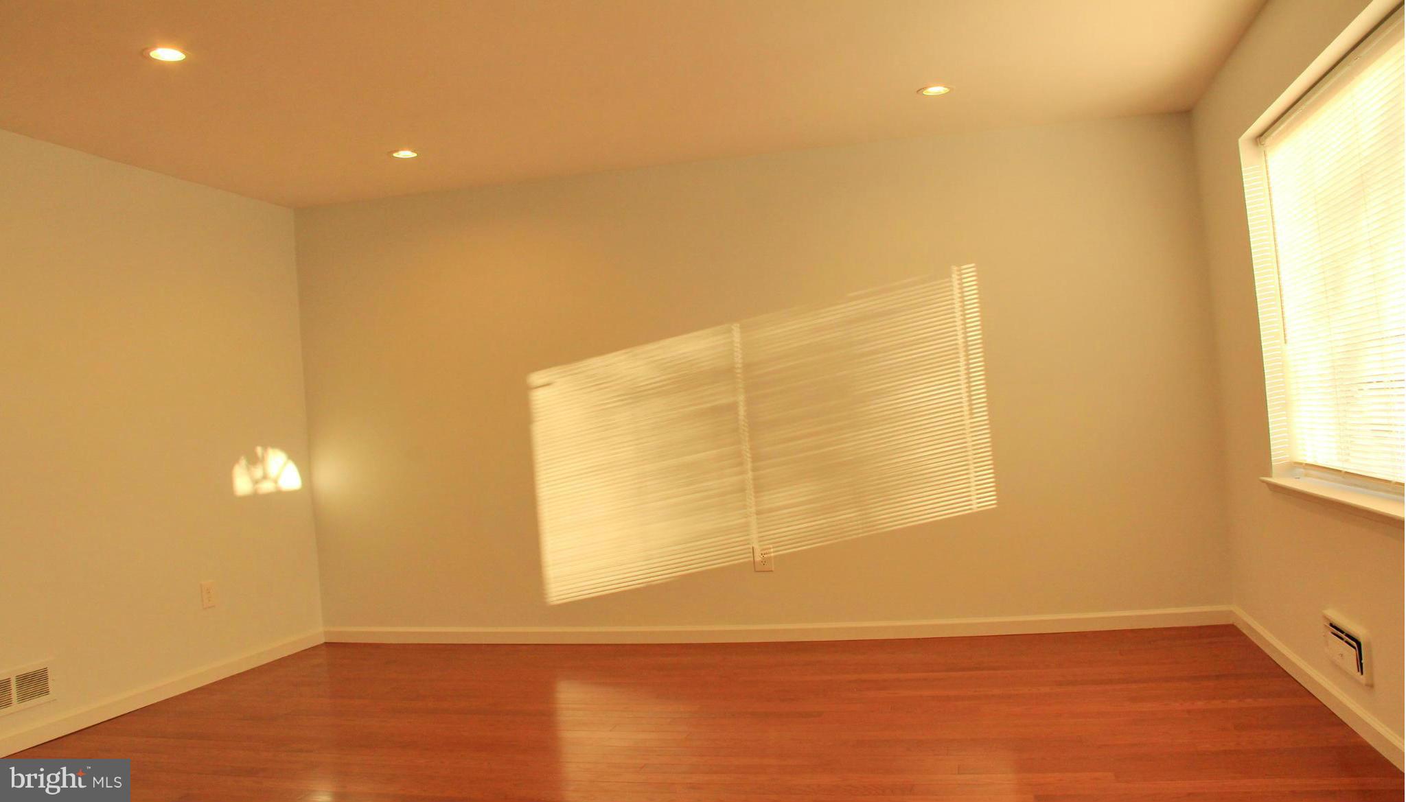 4772 Melbourne Road Baltimore, MD 21229 - Photo 4 of 30 a view of empty room with wooden floor and fan