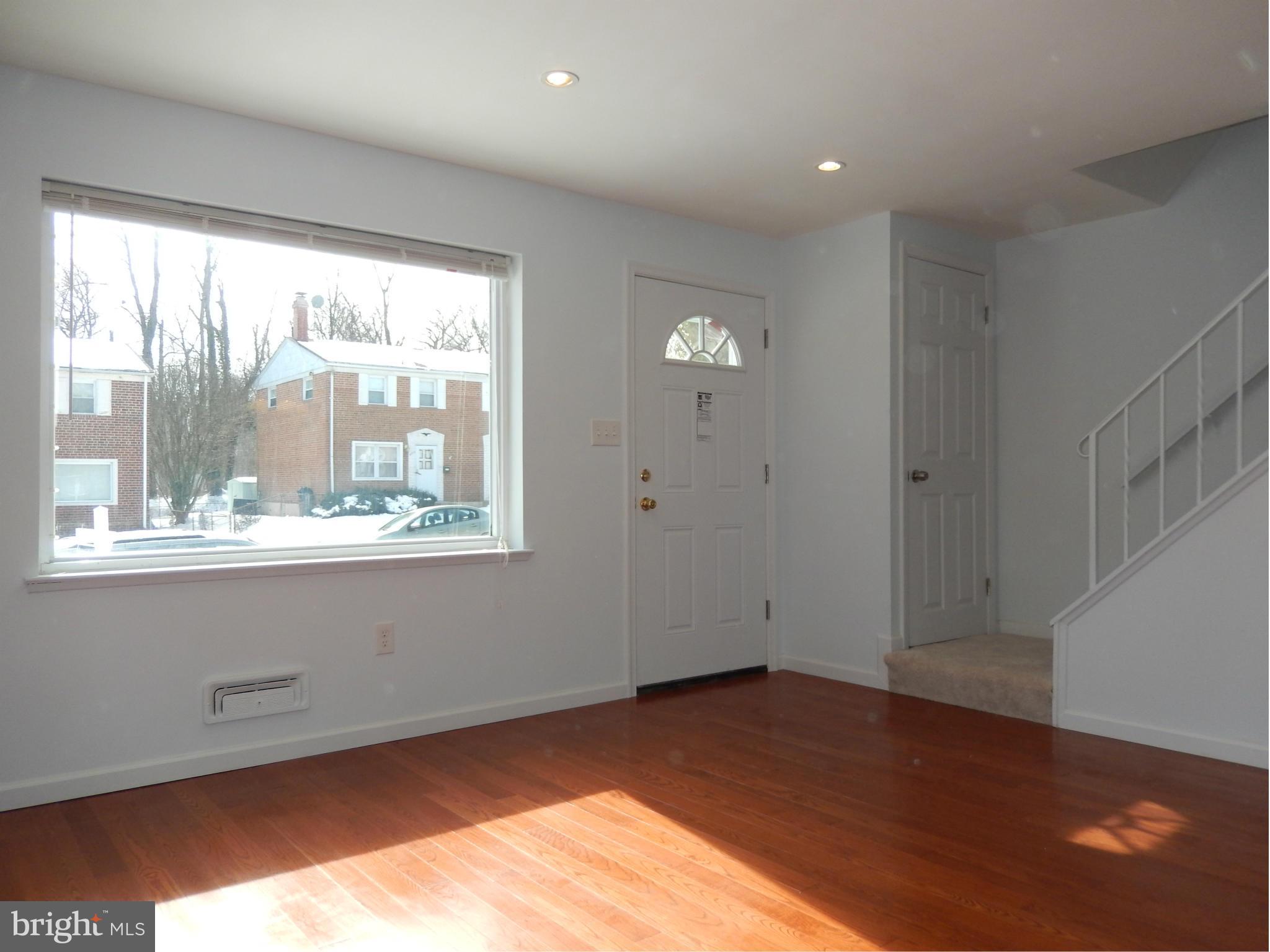 4772 Melbourne Road Baltimore, MD 21229 - Photo 5 of 30 an empty room with wooden floor and windows