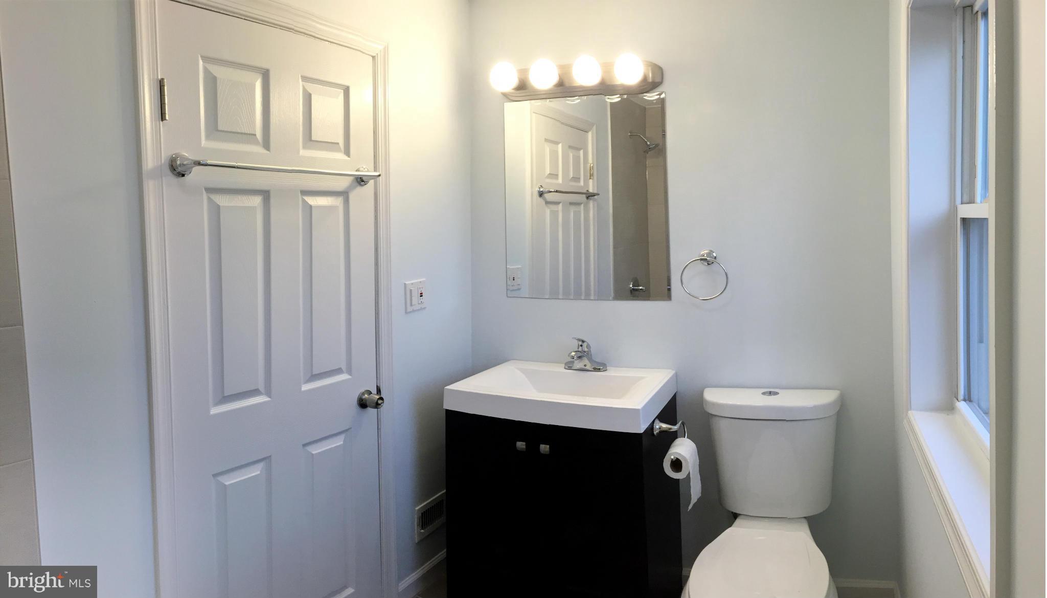 4772 Melbourne Road Baltimore, MD 21229 - Photo 9 of 30 a bathroom with a toilet a sink and mirror