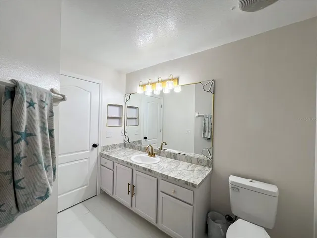 a bathroom with a double vanity sink mirror and toilet