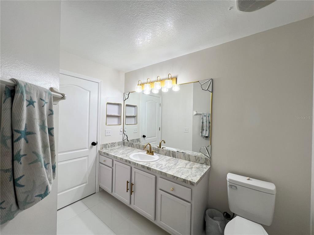 14906 Windy Mt Circle Clermont, FL 34711 - Photo 13 of 26 a bathroom with a double vanity sink mirror and toilet