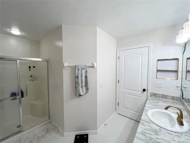 a bathroom with a granite countertop sink and shower