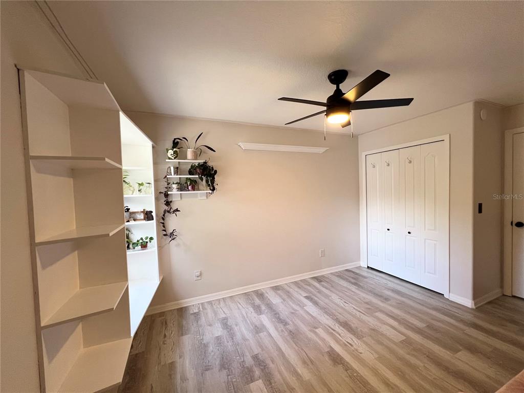 14906 Windy Mt Circle Clermont, FL 34711 - Photo 16 of 26 a view of empty room with wooden floor and fan
