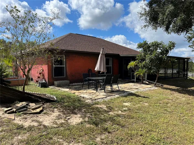 a backyard of a house with barbeque oven and table