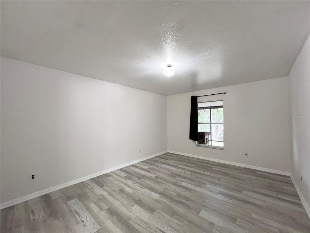 14906 Windy Mt Circle Clermont, FL 34711 - Photo 10 of 26 wooden floor in an empty room with a window