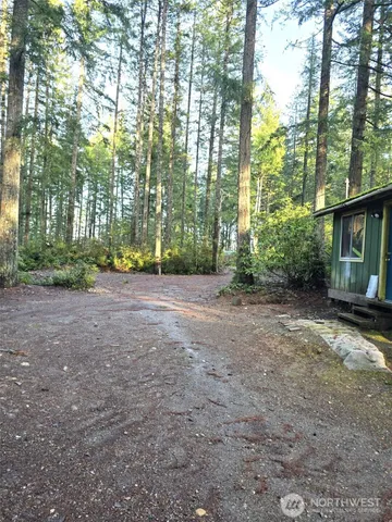 a view of a house with large trees and plants