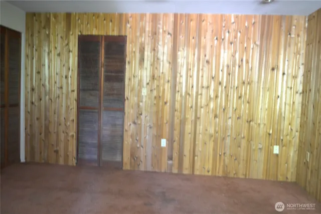 a small barn with a small yard and a large tree