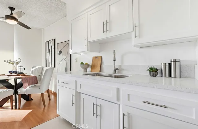 a kitchen with white cabinets and appliances