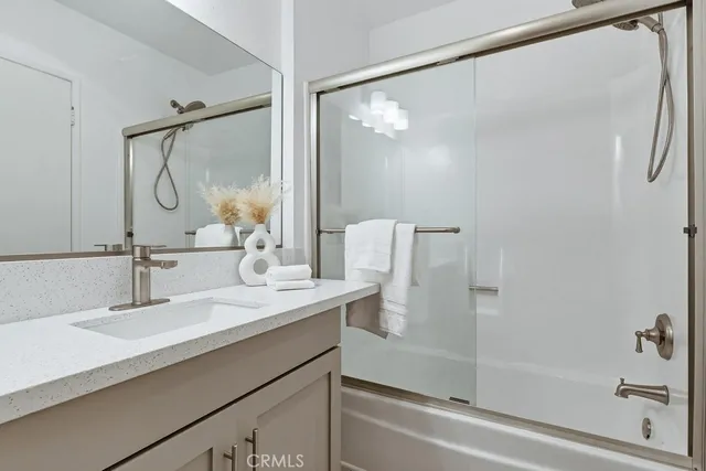 a bathroom with a double vanity sink mirror and shower
