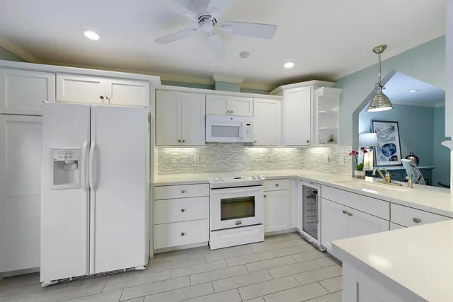 a kitchen with white cabinets and white appliances