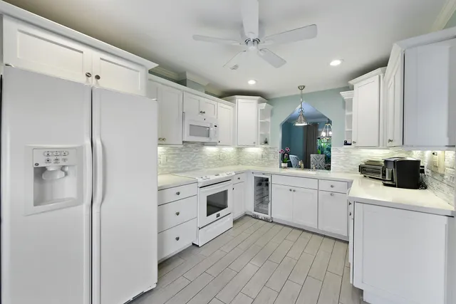 a kitchen with white cabinets and white appliances