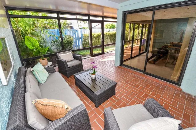 a living room with furniture and a floor to ceiling window