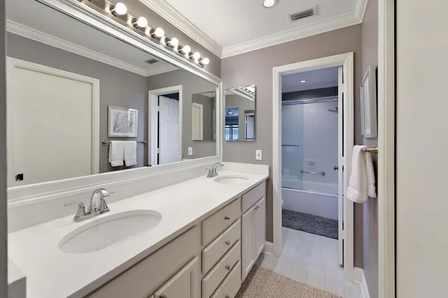 a bathroom with a sink double vanity granite tub and a mirror