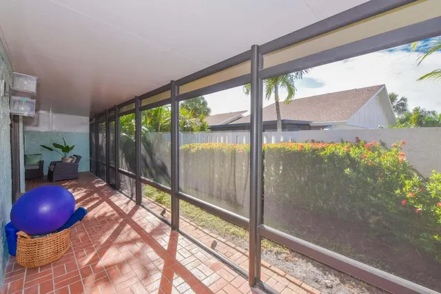 a view of a glass door with a chair and table in the room