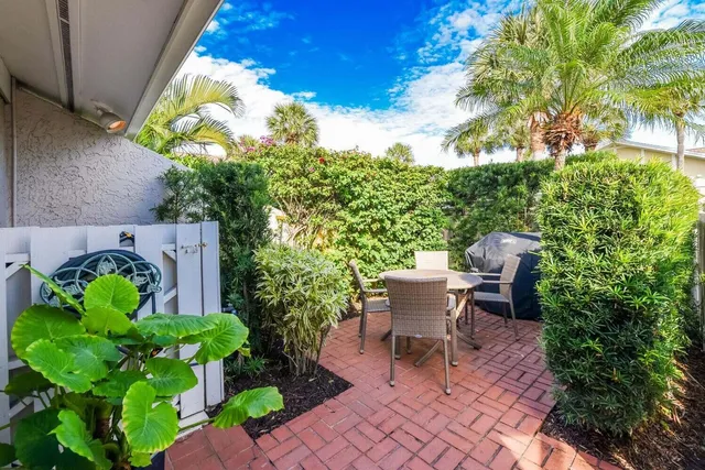 a view of a chair and table in the back yard of the house