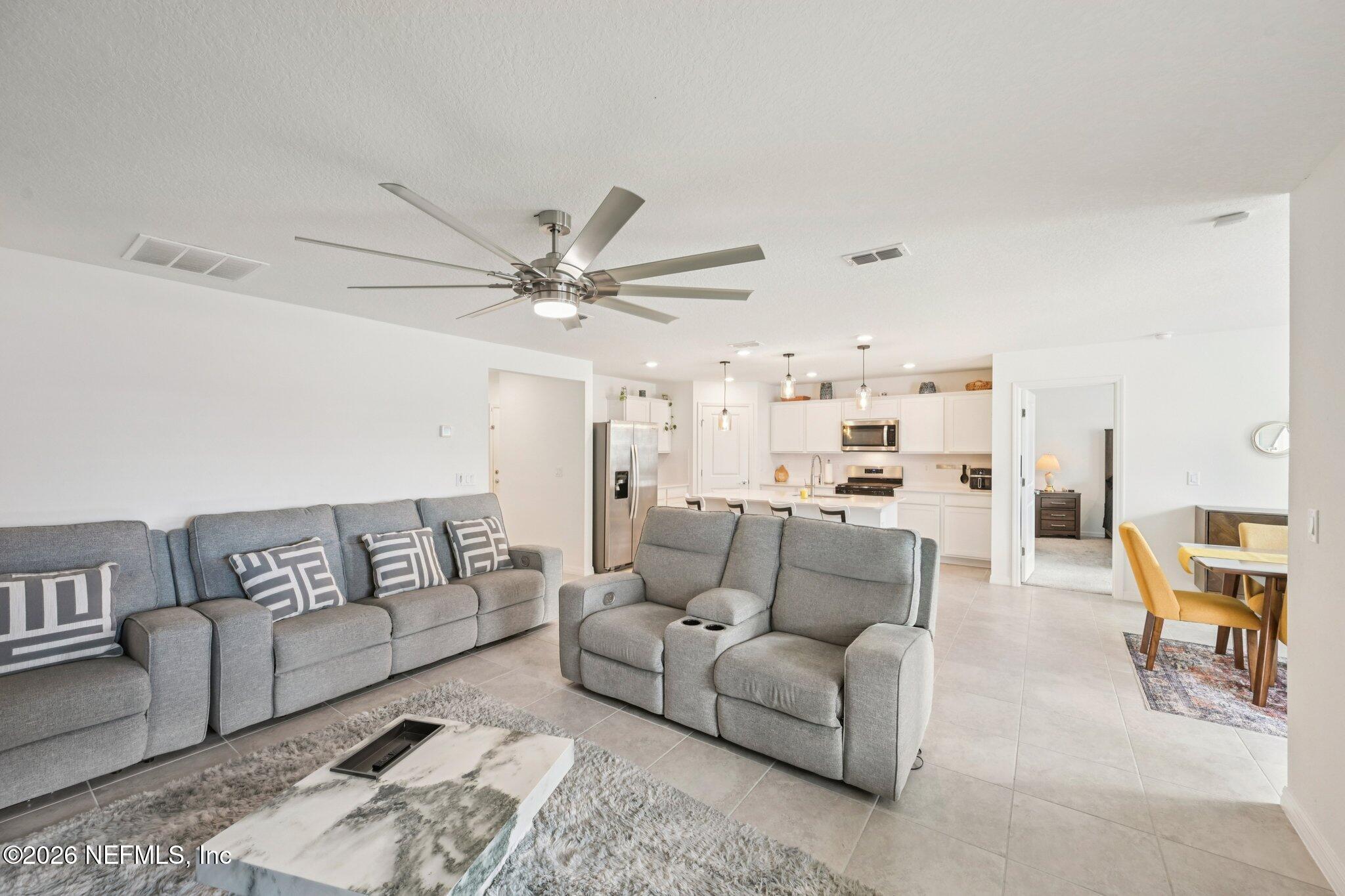 5508 Integrity Way Jacksonville, FL 32244 - Photo 13 of 34 a living room with furniture and a chandelier