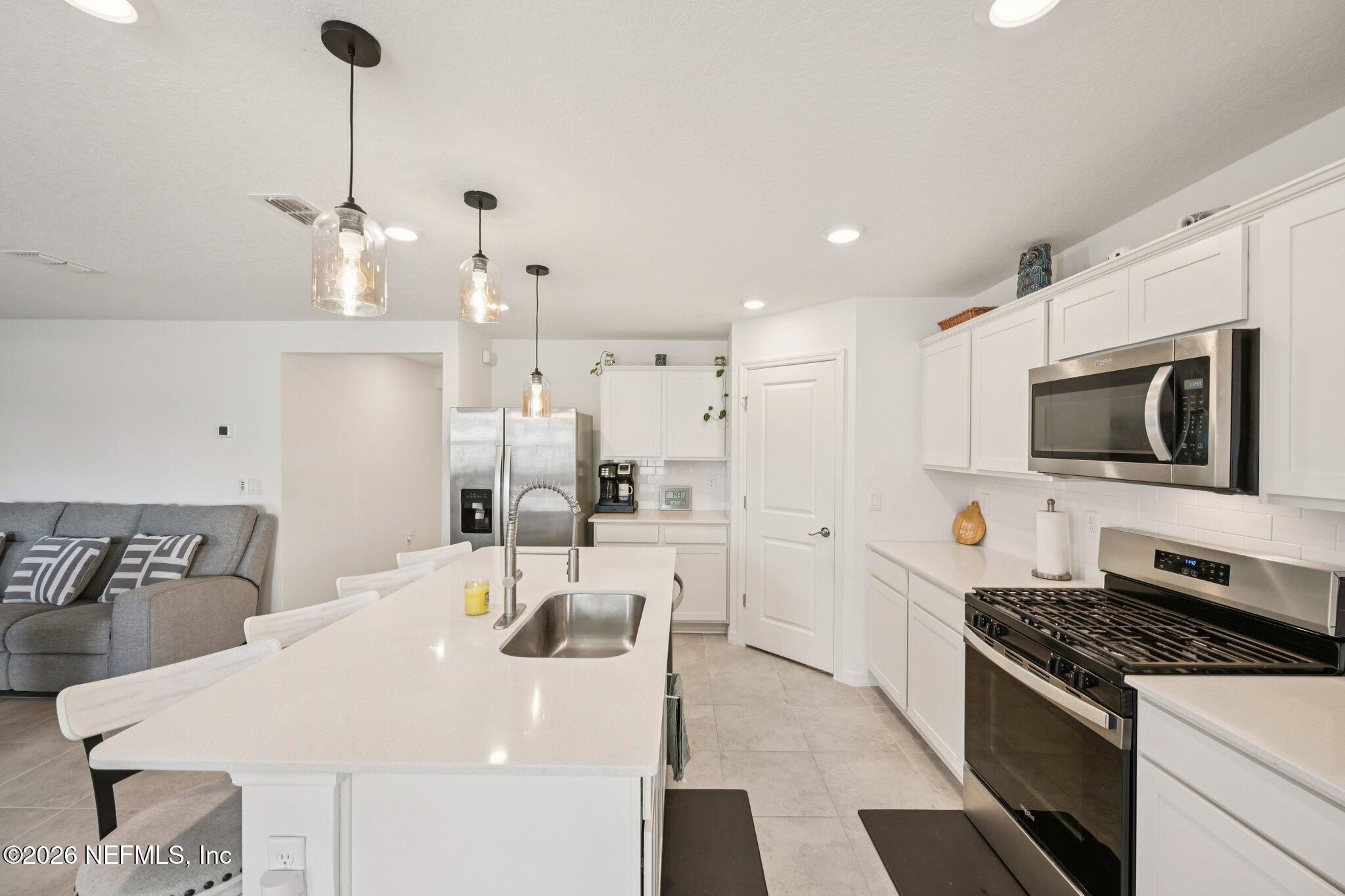5508 Integrity Way Jacksonville, FL 32244 - Photo 19 of 34 a kitchen with a sink a stove and chairs