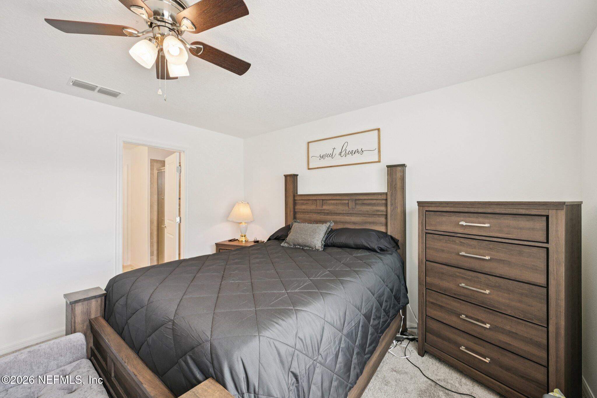 5508 Integrity Way Jacksonville, FL 32244 - Photo 24 of 34 a bedroom with a bed and a chandelier