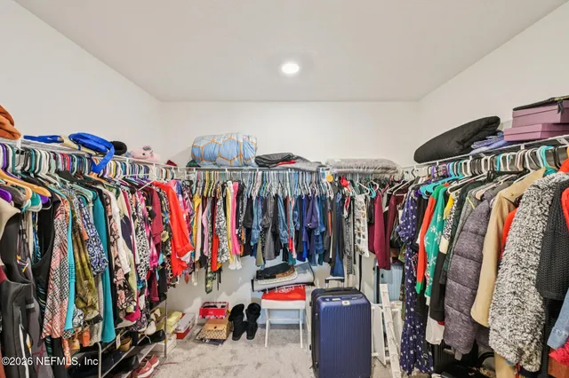 a view of walk in closet with clothes