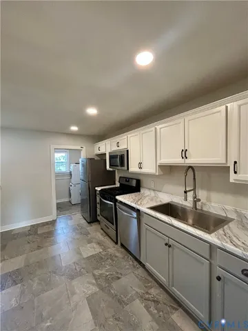 a kitchen with stainless steel appliances granite countertop a sink and cabinets