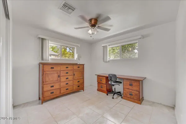 an empty room with furniture and a ceiling fan