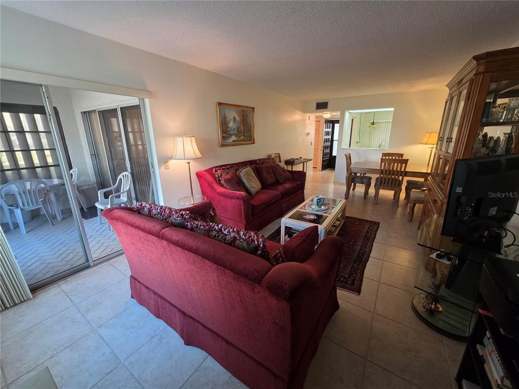 2207 Belleair Road, Unit B6 Clearwater, FL 33764 - Photo 4 of 21 a living room with furniture a flat screen tv and a window