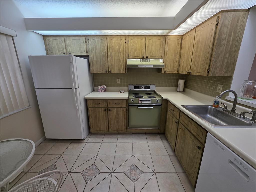 2207 Belleair Road, Unit B6 Clearwater, FL 33764 - Photo 8 of 21 a kitchen with a sink a refrigerator and cabinets
