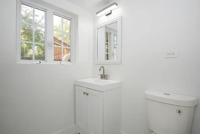 a bathroom with a sink a toilet and window