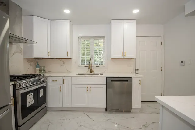 a kitchen with granite countertop cabinets stainless steel appliances and a sink