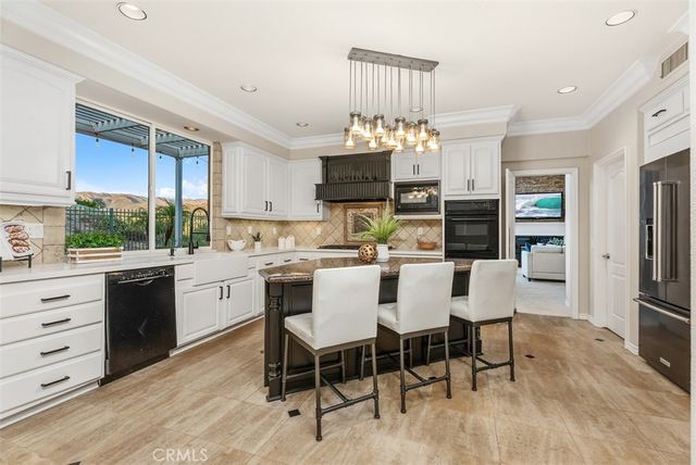 a kitchen with granite countertop white cabinets and black appliances