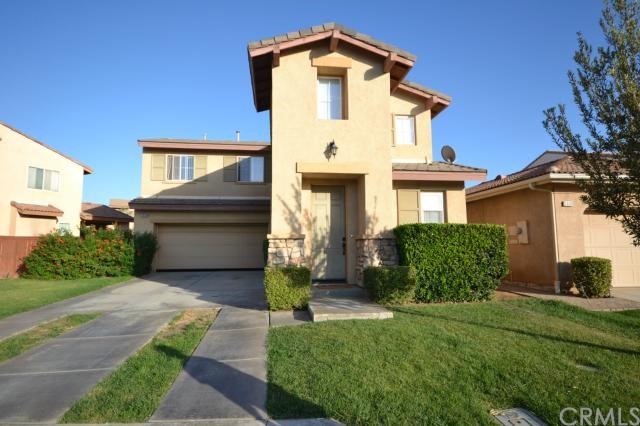 a front view of a house with a yard and potted plants