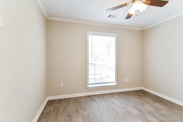 an empty room with a window and wooden floor