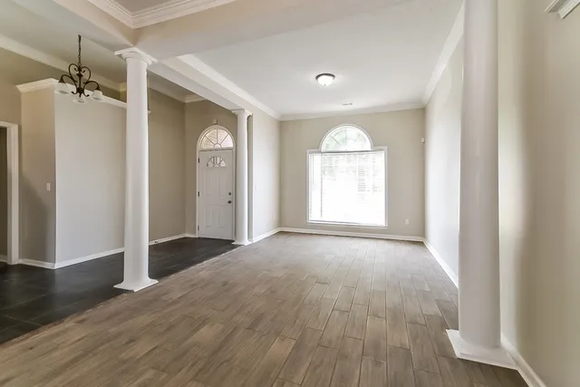 an empty room with wooden floor and a window