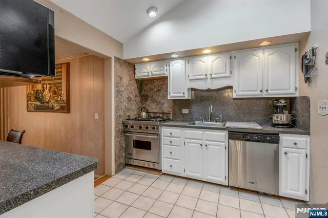 a kitchen with white cabinets and appliances