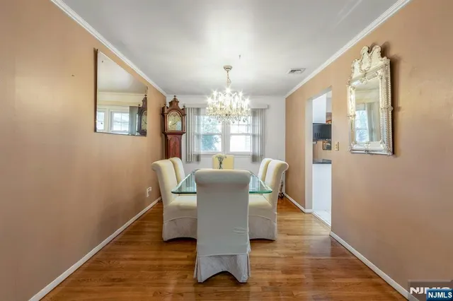 a dining room with furniture a chandelier and wooden floor