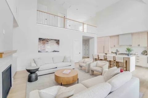a living room with furniture a rug and kitchen view