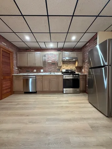 a large kitchen with stainless steel appliances granite countertop a sink and stove