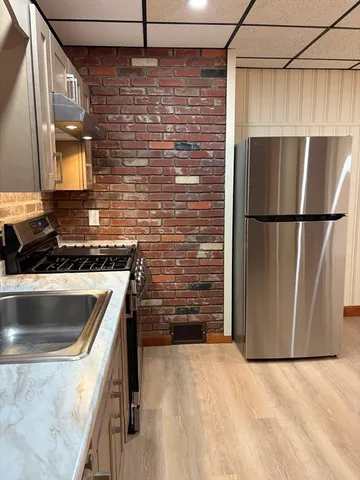 a kitchen with granite countertop a refrigerator and a sink