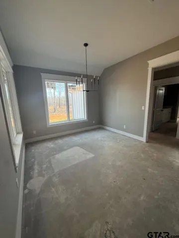 an empty room with windows and ceiling fan