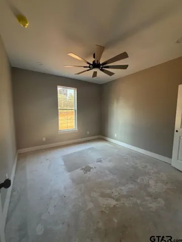 an empty room with chandelier fan