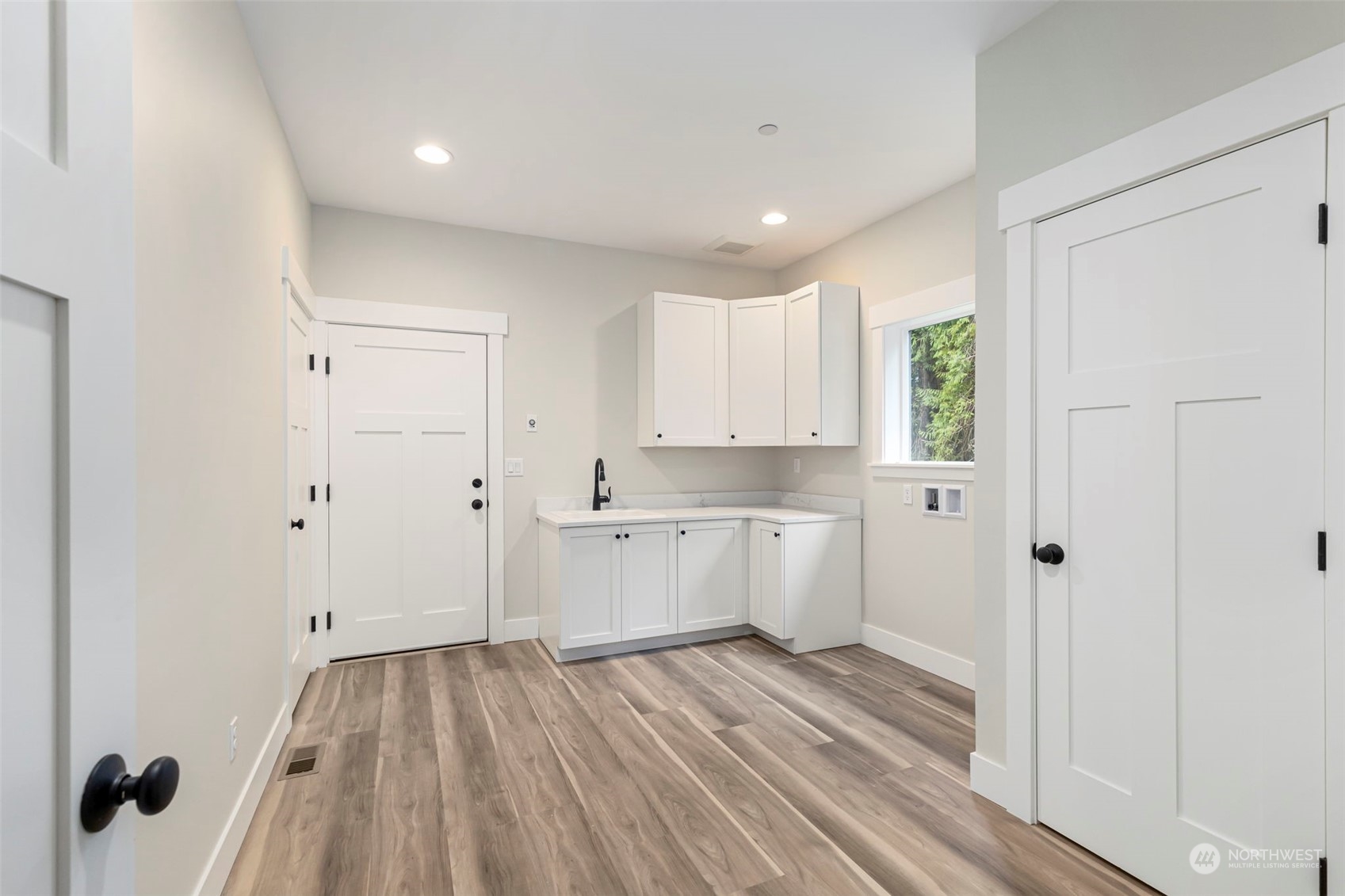 22086 Dewberry Road Northeast Indianola, WA 98342 - Photo 29 of 40 a view of a kitchen with white cabinets and wooden floor