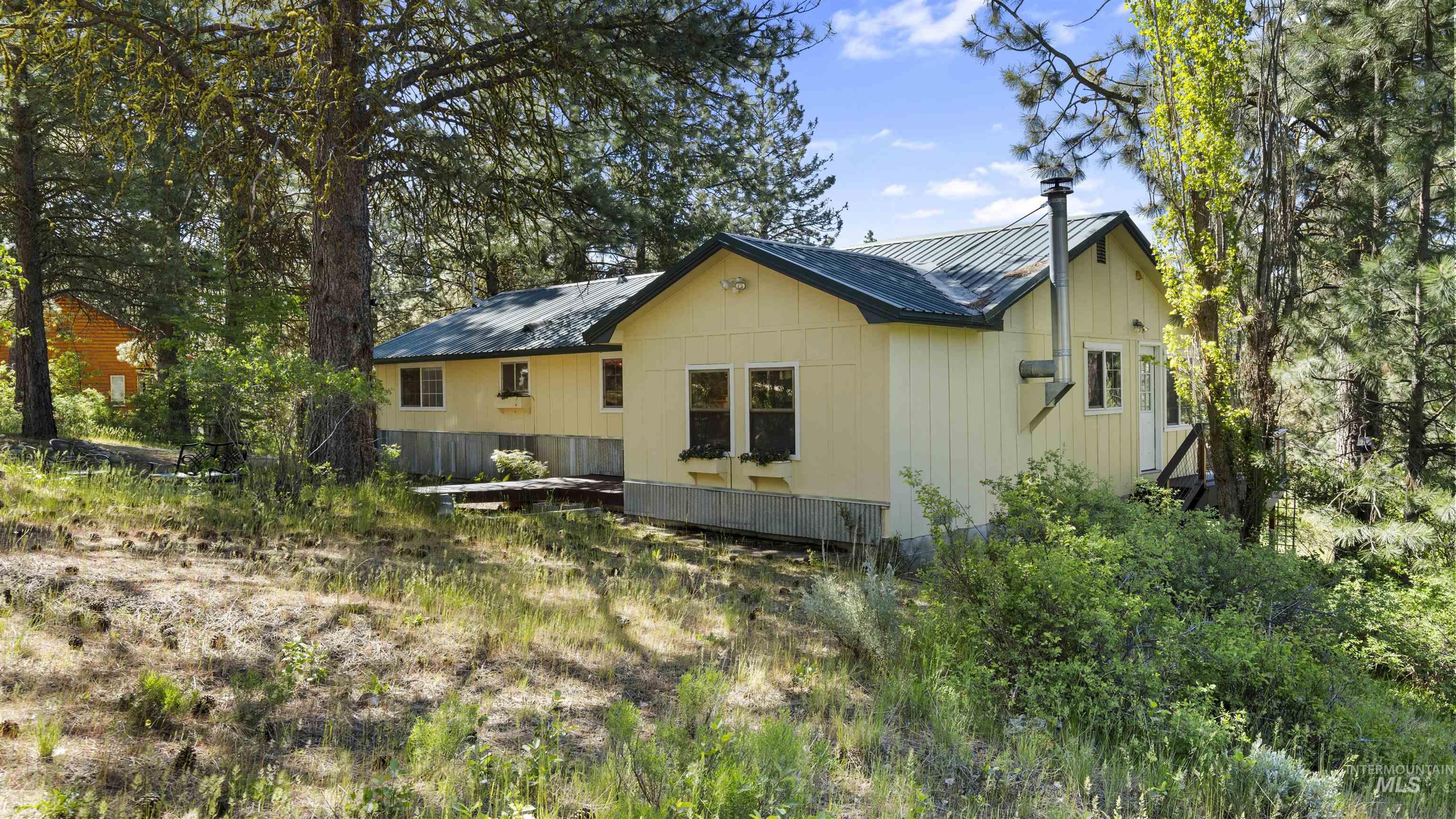 3 Laguna Place Cascade, ID 83611 - Photo 38 of 43 Yellow siding with corrugated metal skirting and a deep green metal roof