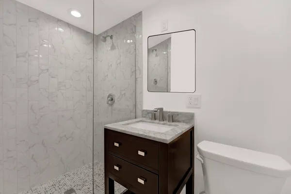 a bathroom with a sink vanity granite and toilet