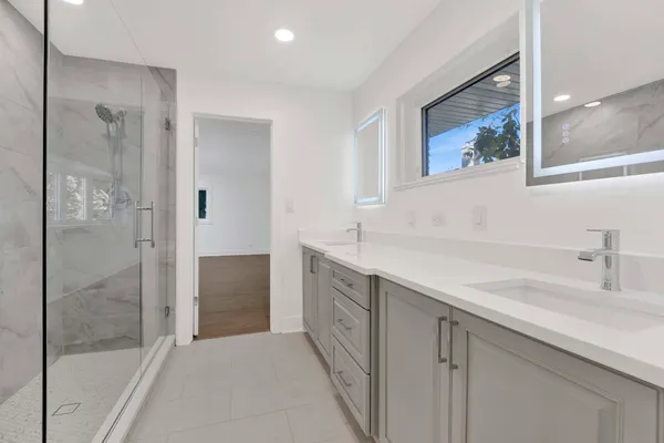 a spacious bathroom with a shower sink and mirror