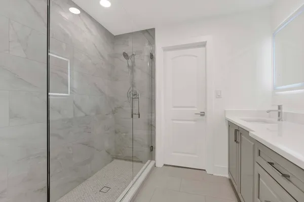 a bathroom with a granite countertop sink a shower and a mirror